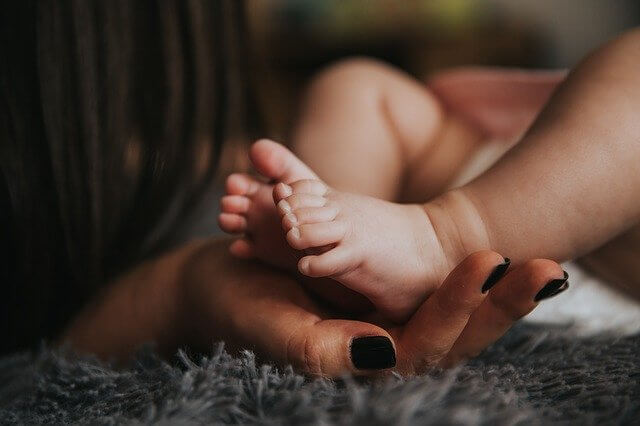 赤ちゃんの足とママの手